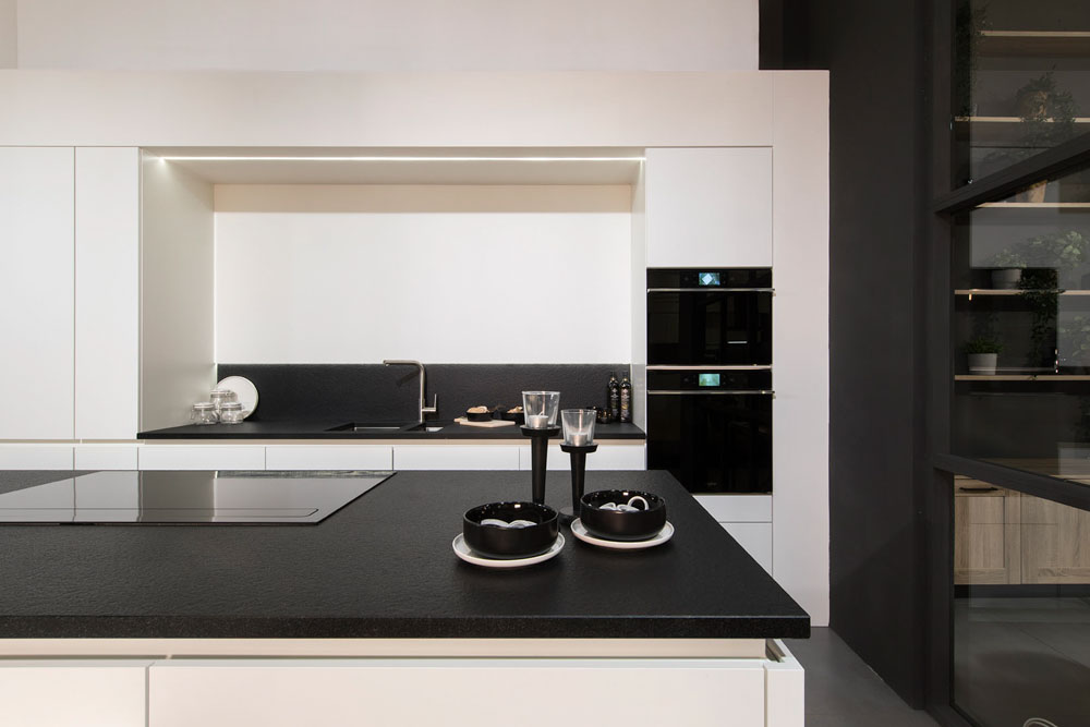 witte keuken met zwarte toestellen